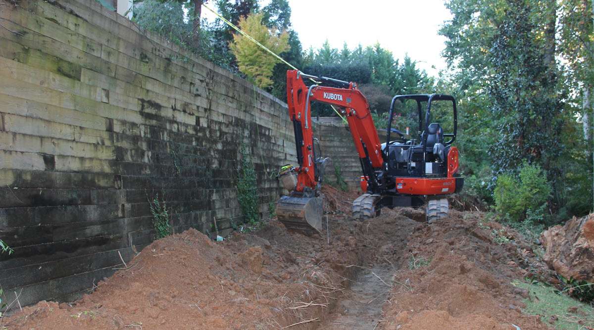 Retaining wall installation to divert water run-off