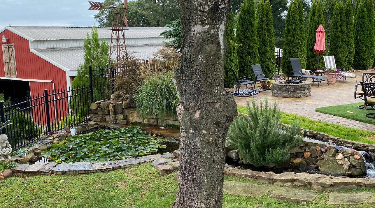 Beautiful water feature with fish pond and waterfall beside paver pool deck